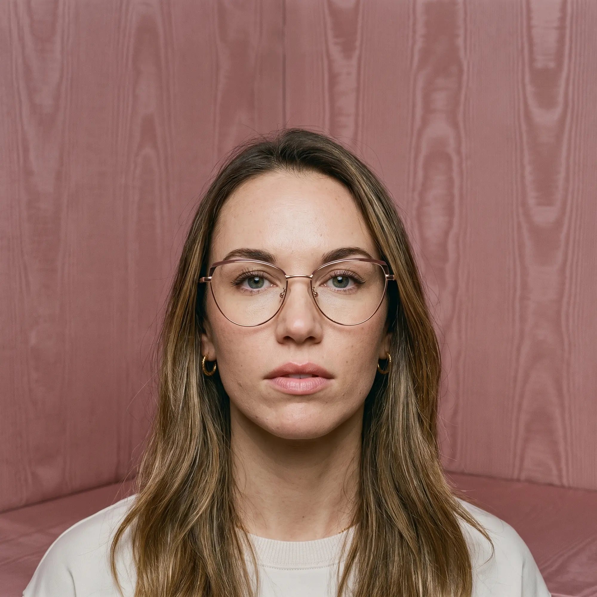 Anteojos Fiore 3983 en brown gold, en modelo – retrato de campaña, face framed by rose moire upholstery