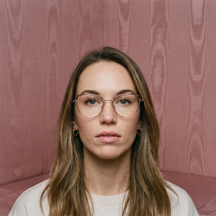 Anteojos Fiore 3983 en brown gold, en modelo – retrato de campaña, face framed by rose moire upholstery