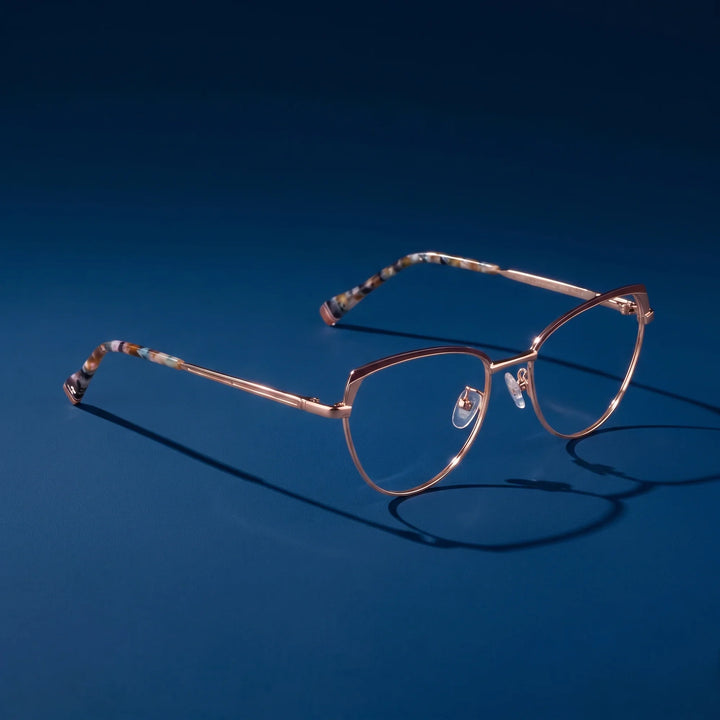 Anteojos Fiore 3983 en brown gold – hero still life against a deep midnight blue backdrop
