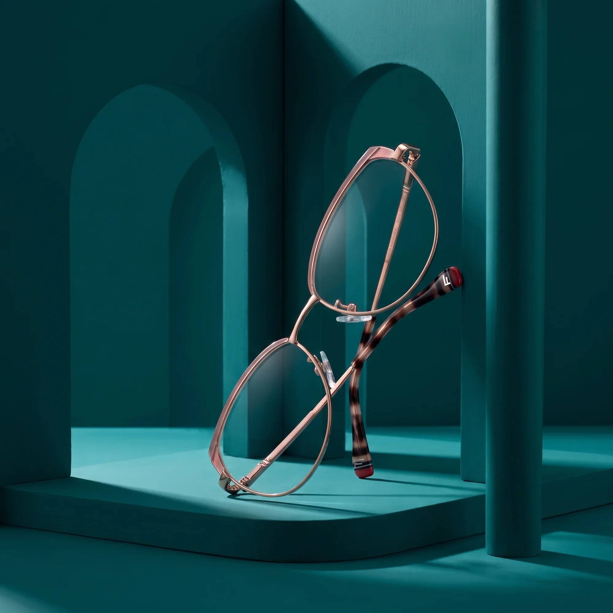 Anteojos Fiore 3983 en pink gold – still life among monochrome teal arches