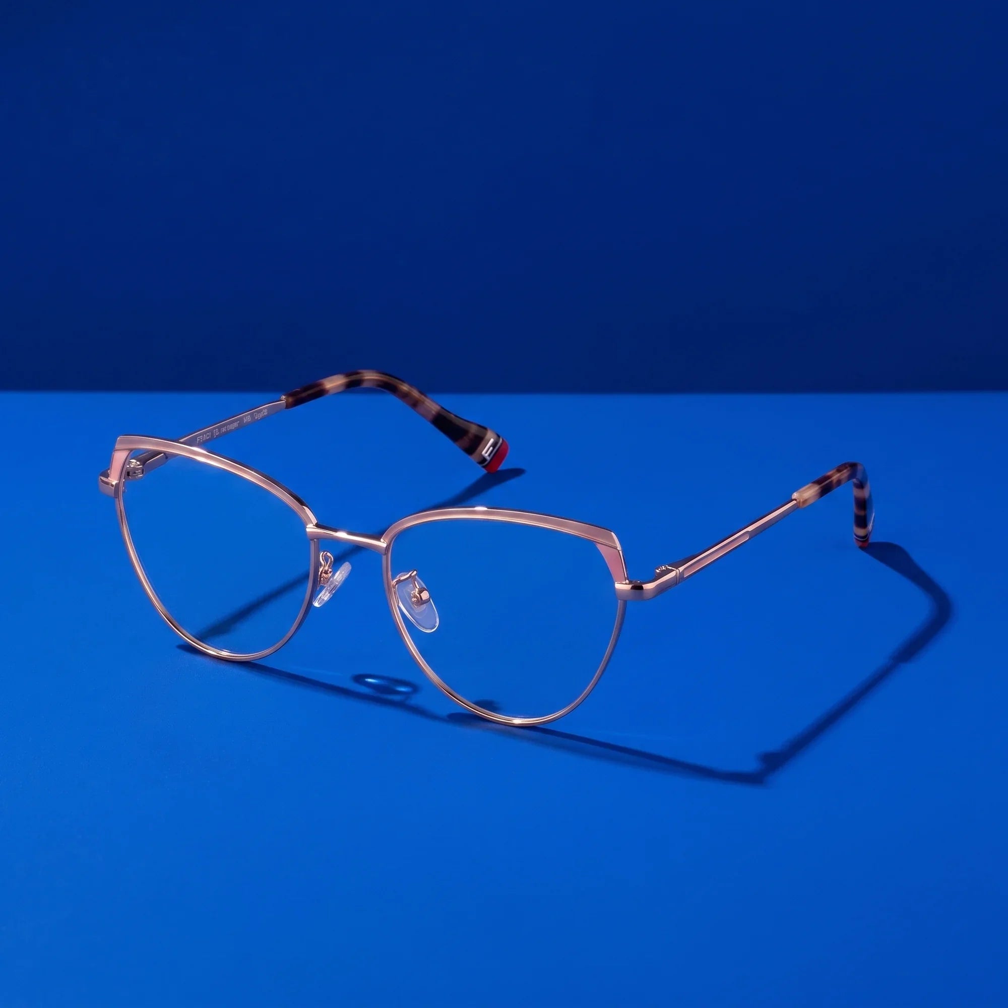 Anteojos Fiore 3983 en pink gold – bodegón sobre fondo cobalto de estudio