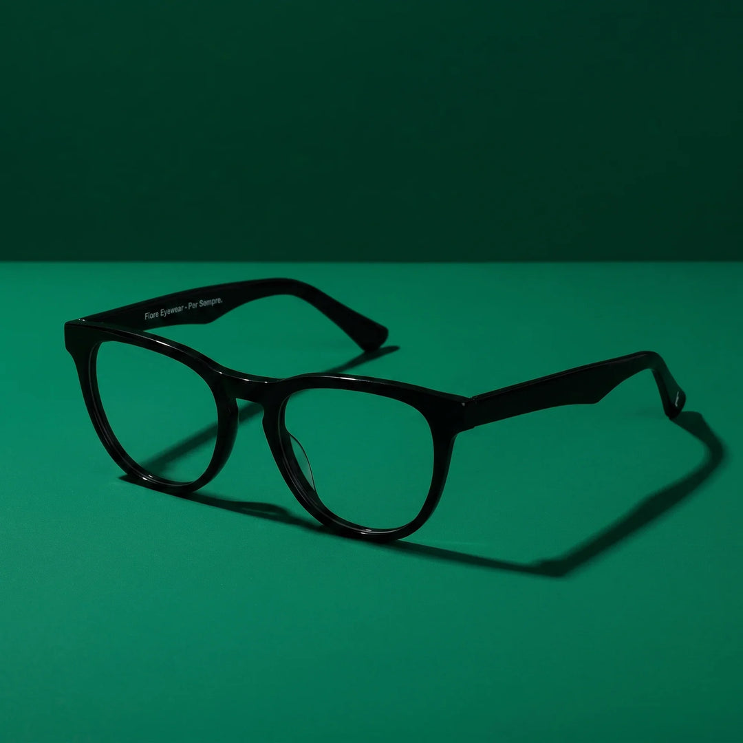 Anteojos Fiore 4488 en negro – still life on a seamless emerald studio backdrop