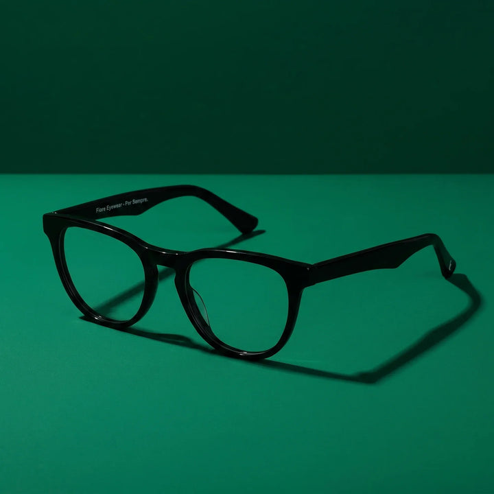 Anteojos Fiore 4488 en negro – still life on a seamless emerald studio backdrop
