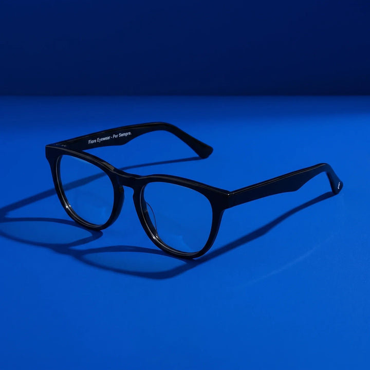 Anteojos Fiore 4488 en negro – hero still life against a deep cobalt backdrop