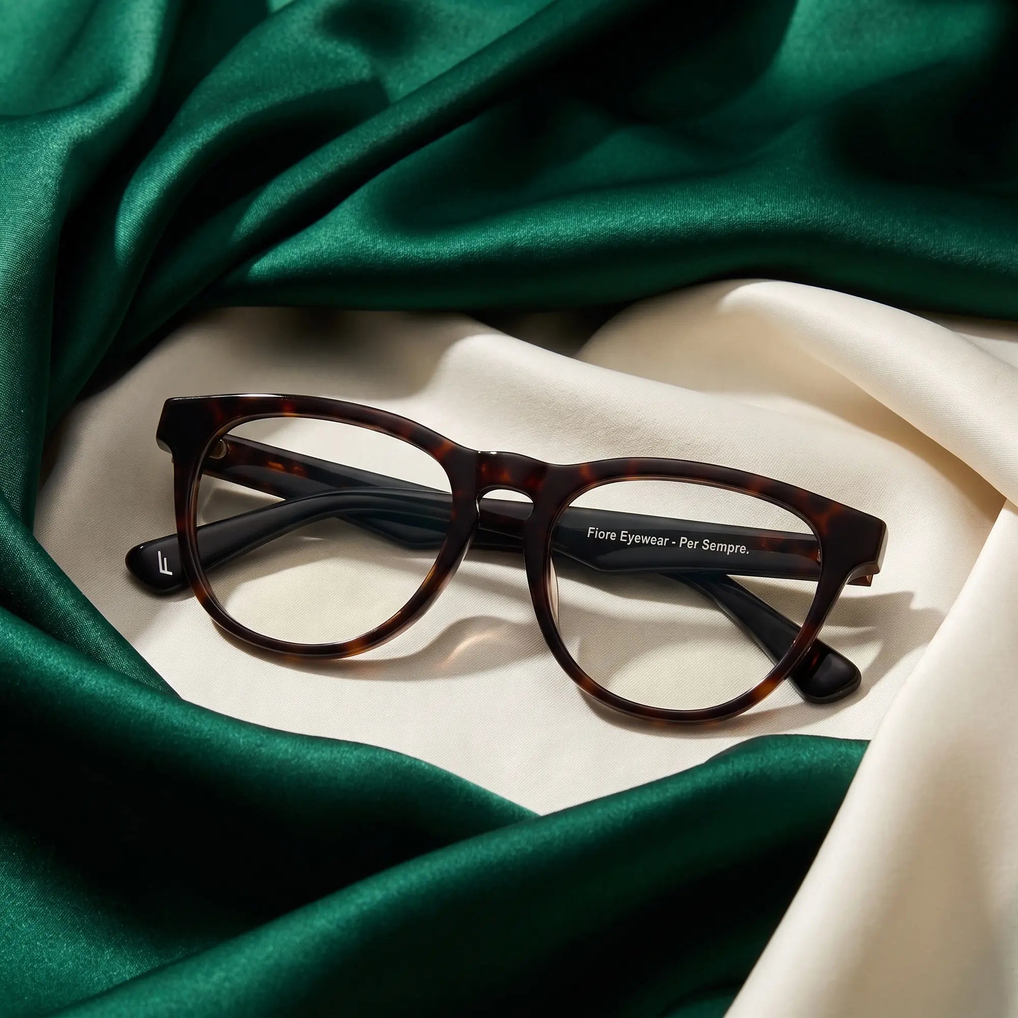 Anteojos Fiore 4488 en tortoiseshell – resting on draped emerald and ivory silk