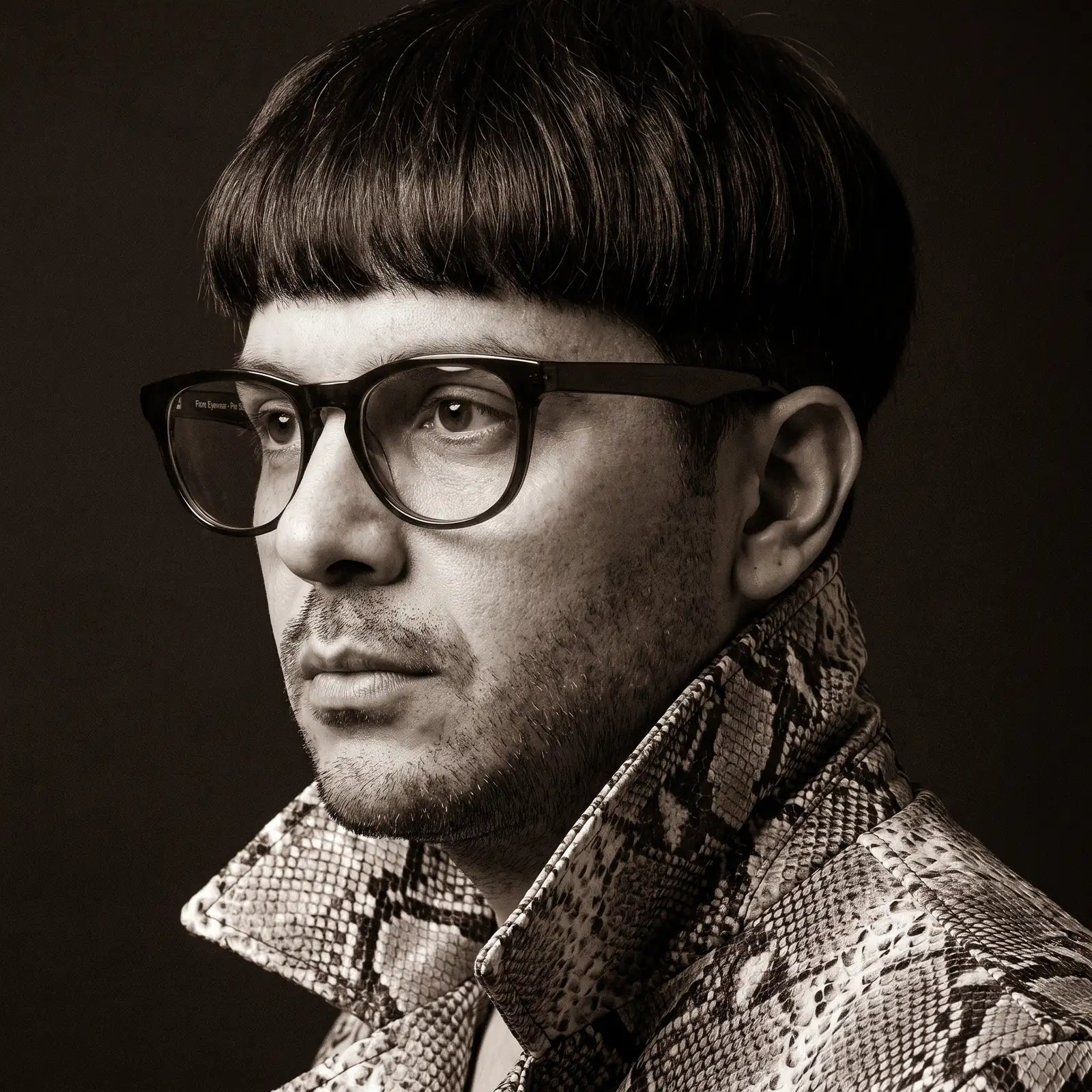 Anteojos Fiore 4488 en verde, en modelo – retrato de campaña, monochrome studio portrait, red graphic accents