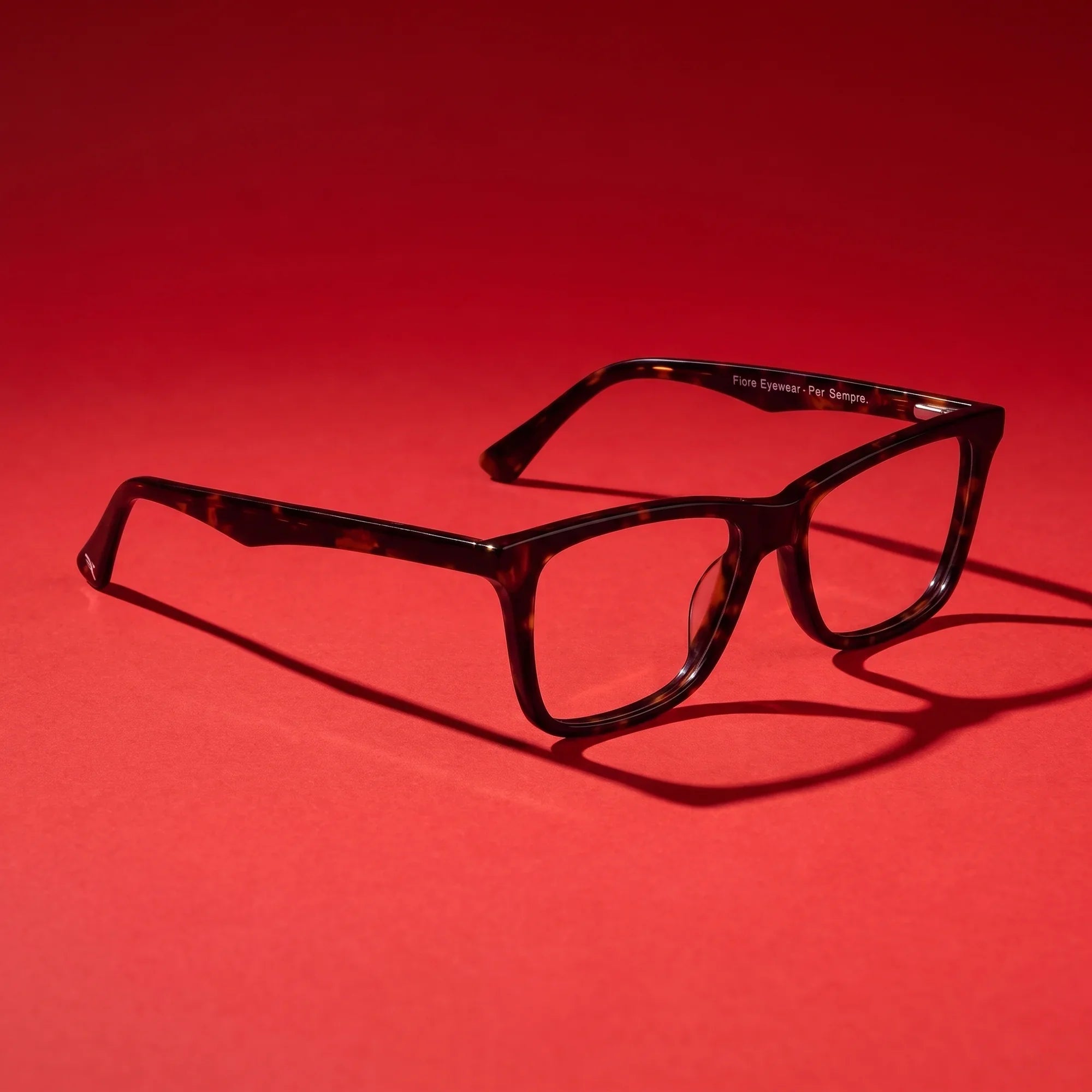 Anteojos Fiore 5228 en tortoiseshell – editorial still life on a saturated vivid red set
