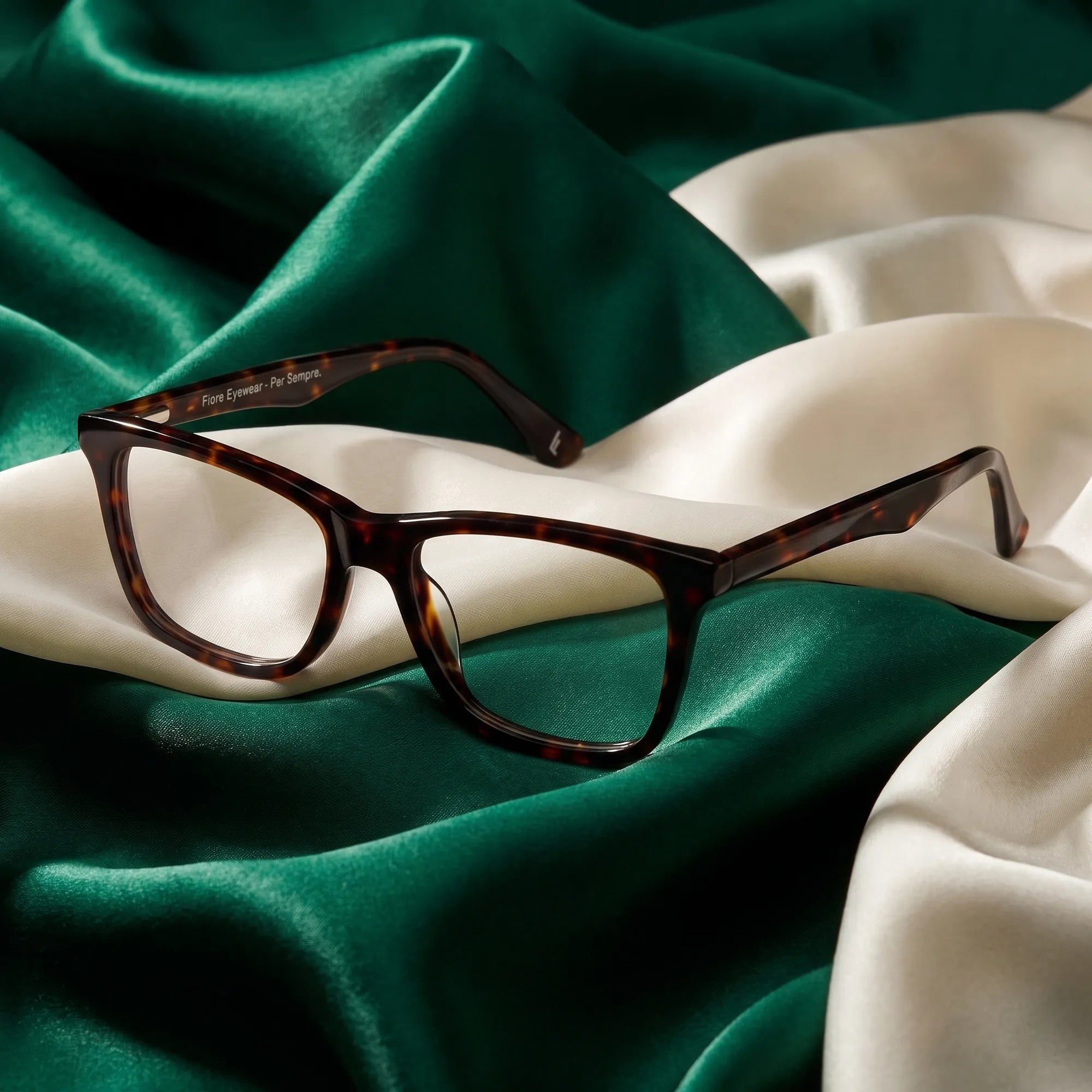 Anteojos Fiore 5228 en tortoiseshell – resting on draped emerald and ivory silk