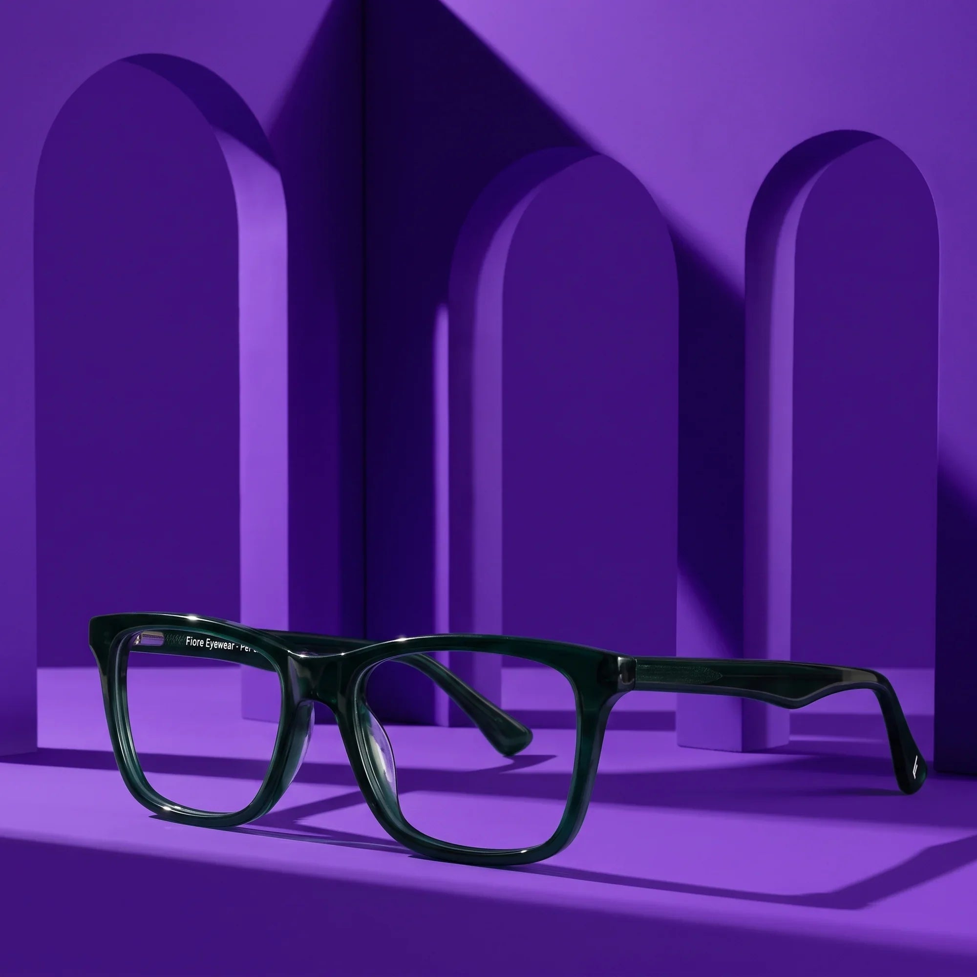 Anteojos Fiore 5228 en verde – displayed on a violet podium among arches