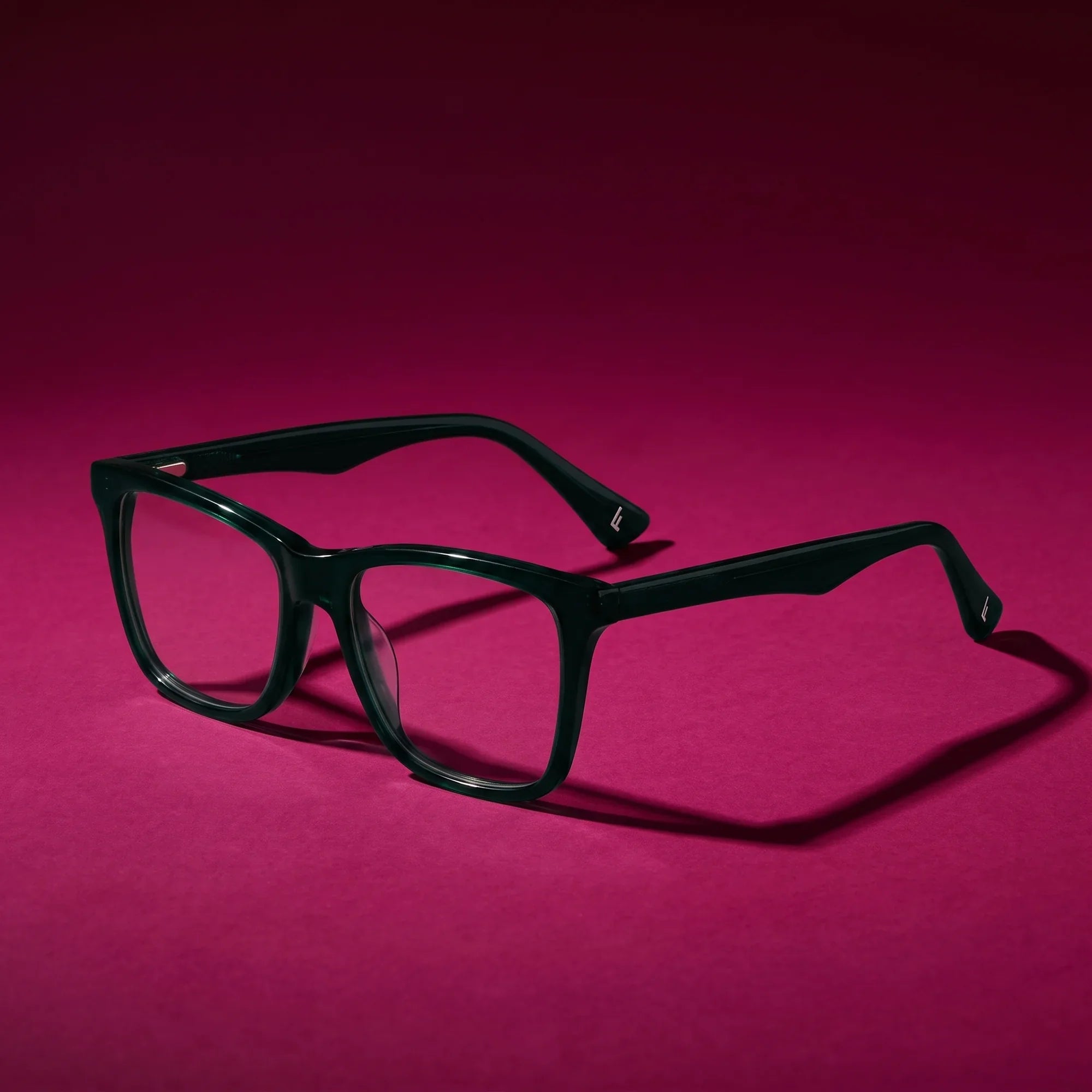 Anteojos Fiore 5228 en verde – hero still life against a deep magenta backdrop