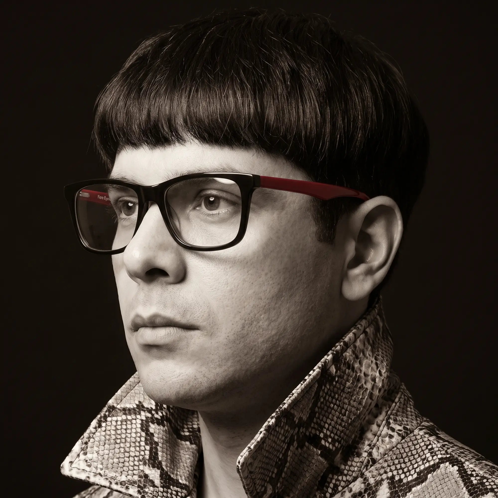 Anteojos Fiore 5228 en negro, en modelo – retrato de campaña, monochrome studio portrait, red graphic accents