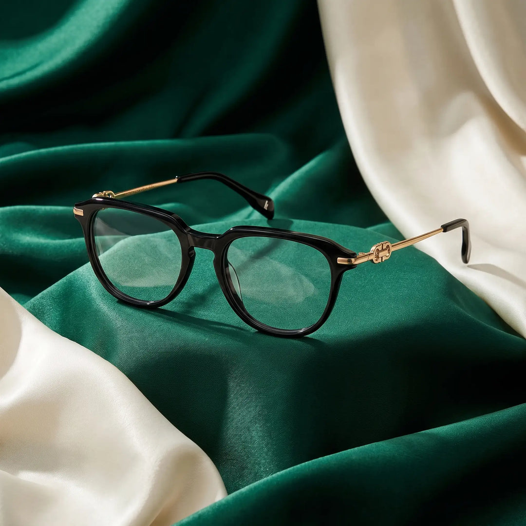 Anteojos Fiore 5409 en negro – resting on draped emerald and ivory silk