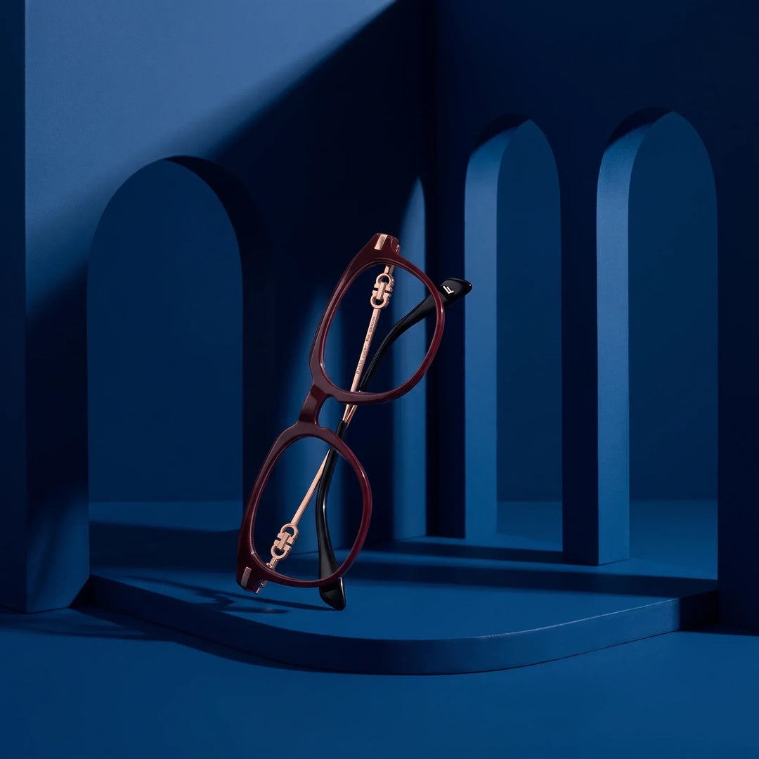 Anteojos Fiore 5409 en café rojo – staged on a sculptural midnight blue architecture set
