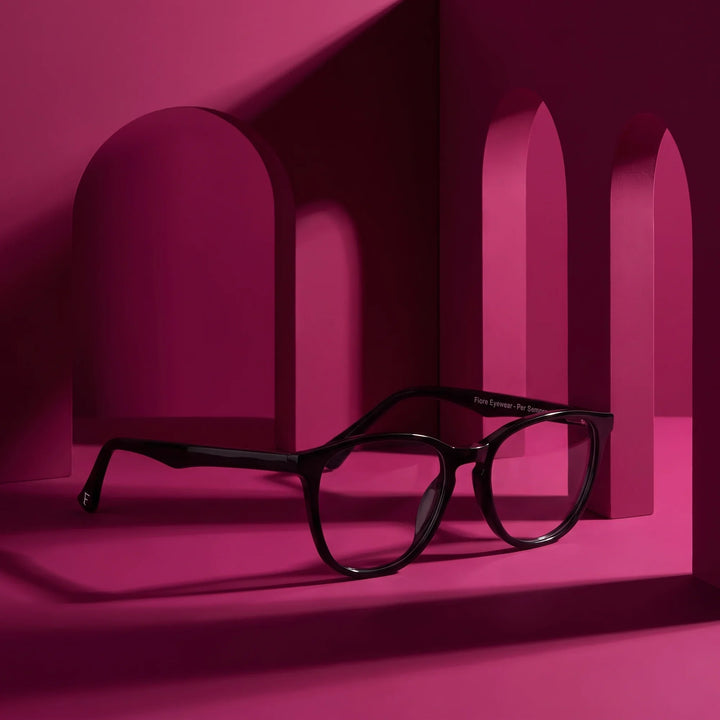 Anteojos Fiore 7046 en negro – staged on a sculptural magenta architecture set