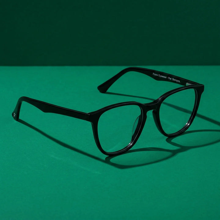 Anteojos Fiore 7046 en negro – still life on a seamless emerald studio backdrop