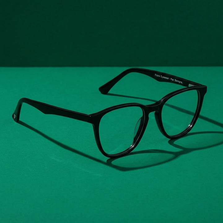 Anteojos Fiore 7046 en negro – still life on a seamless emerald studio backdrop