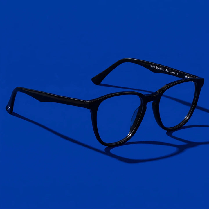 Anteojos Fiore 7046 en negro – hero still life against a deep cobalt backdrop