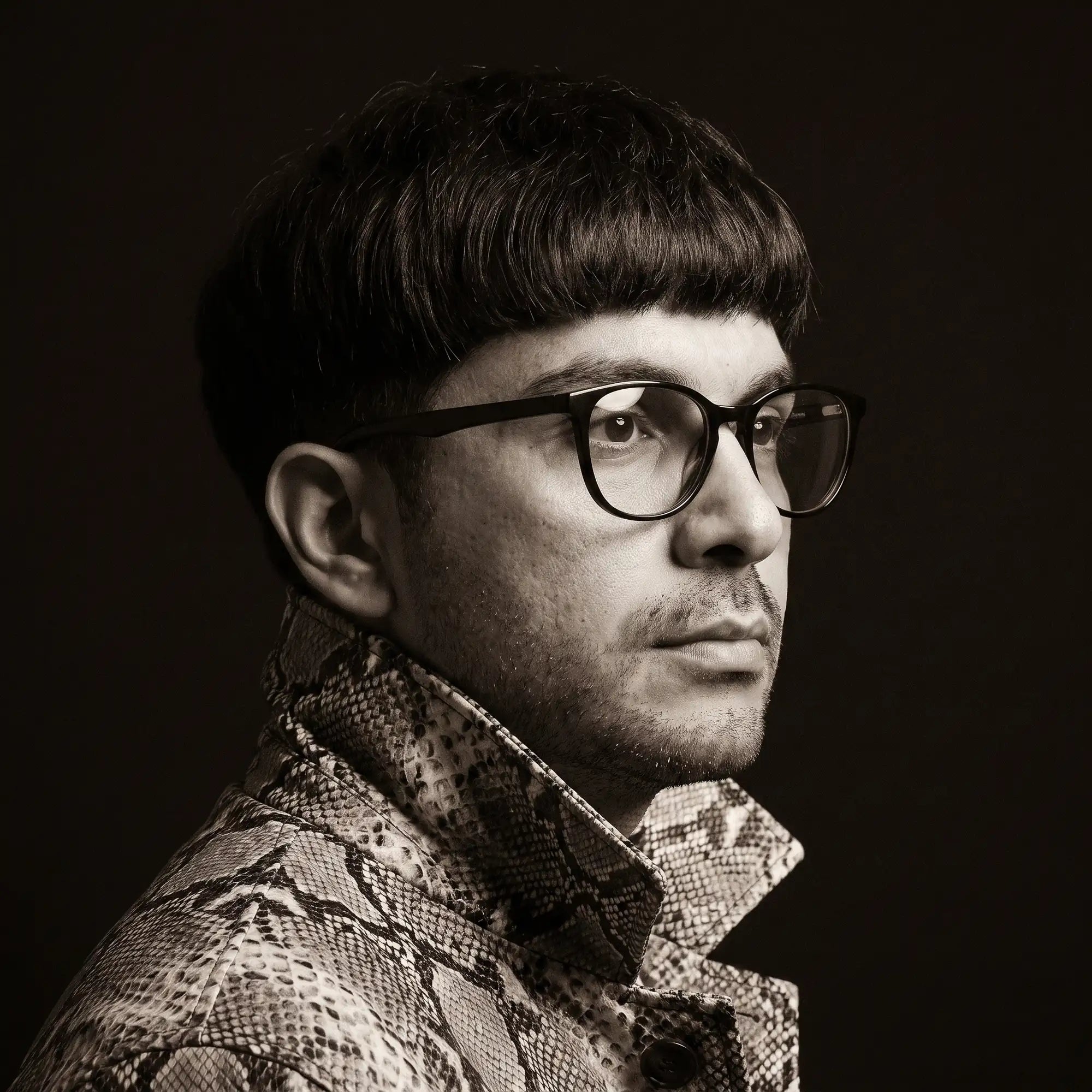 Anteojos Fiore 7046 en negro, en modelo – retrato de campaña, monochrome studio portrait, red graphic accents
