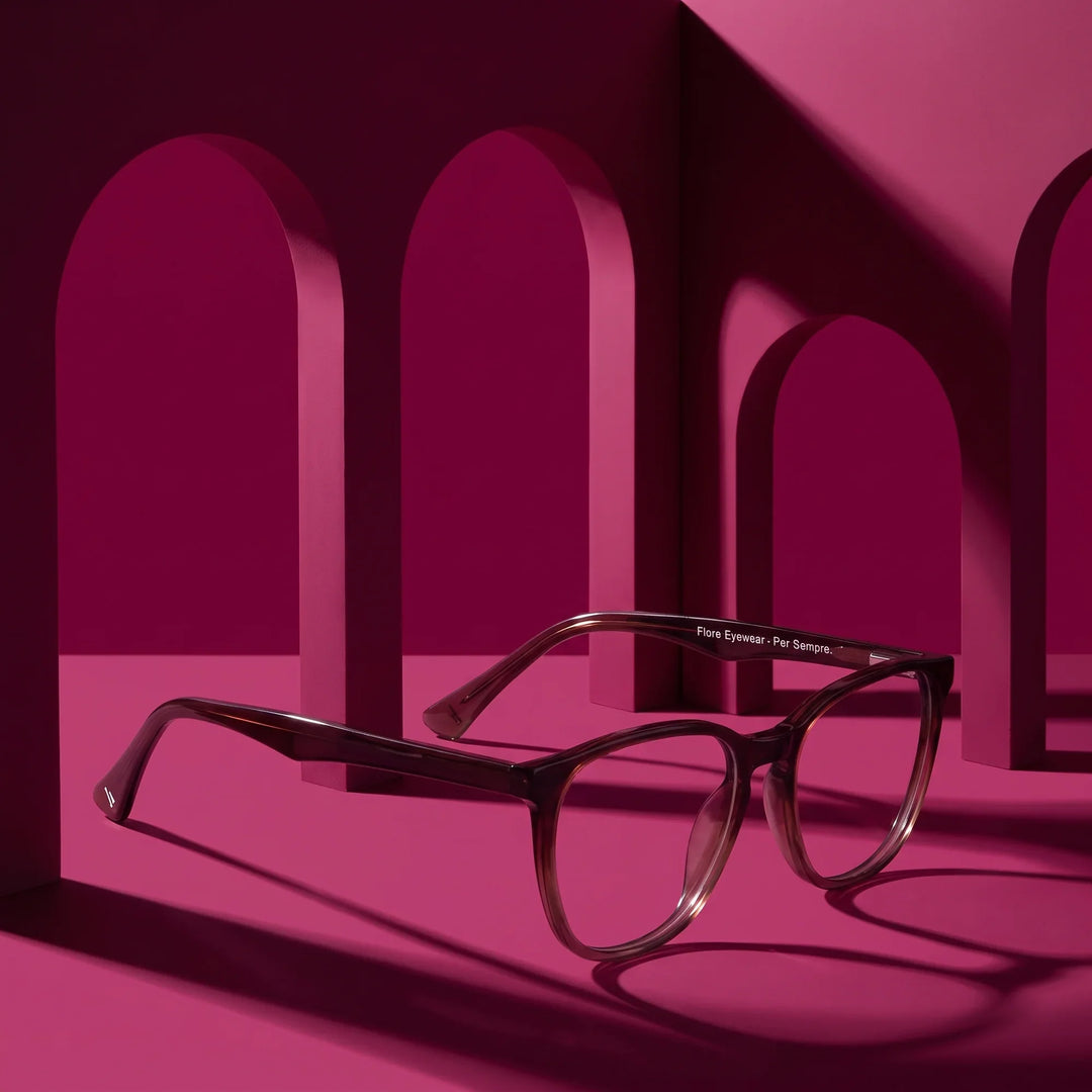 Anteojos Fiore 7046 en gradual brown – displayed on a magenta podium among arches