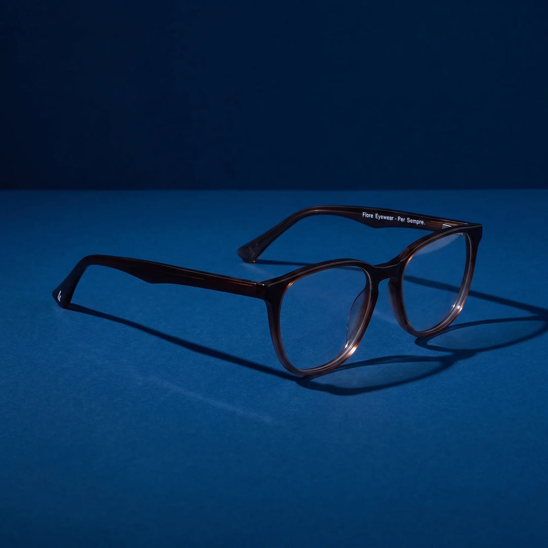 Anteojos Fiore 7046 en gradual brown – hero still life against a deep midnight blue backdrop
