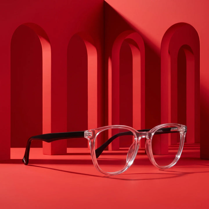 Anteojos Fiore 7046 en transparente – displayed on a vivid red podium among arches