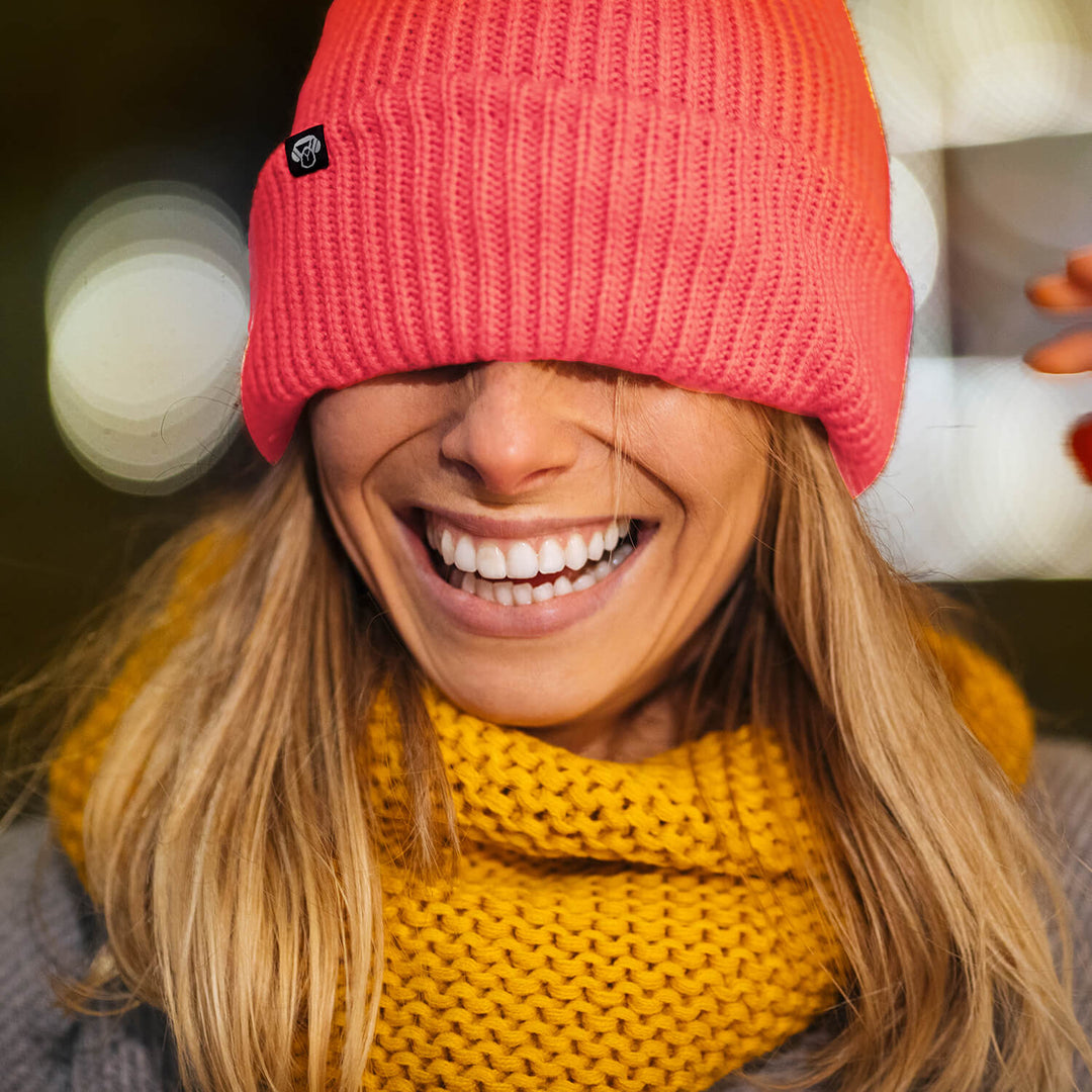 mujer de pelo rubio con un gorro beanie de nylon reciclado sustentable amigable con el medioambiente riendose. Bonoboss regalos corporativos sustentables