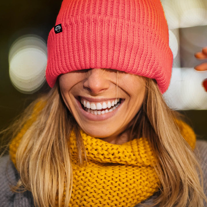 mujer de pelo rubio con un gorro beanie de nylon reciclado sustentable amigable con el medioambiente riendose. Bonoboss regalos corporativos sustentables