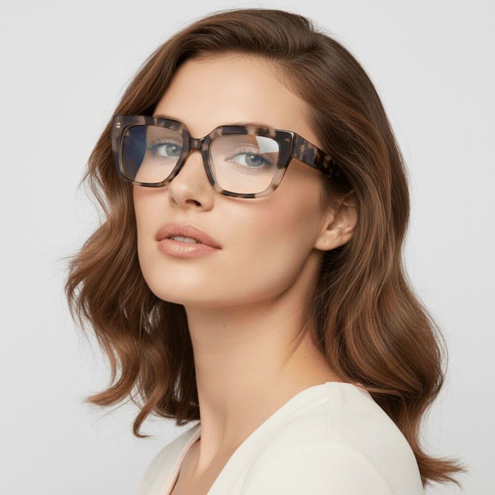 una modelo mujer de cara redonda ojos verdes y pelo suelto ondulado usando un anteojo o marco optico Bonoboss en acetato sustentable armazones opticos con receta de forma cuadrada rectangular de moda de tamaño grande y de color marble marmoleado #color_marble