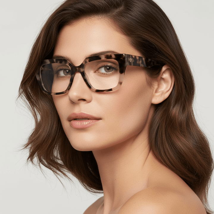 una modelo mujer de cara redonda ovalada de ojos verdes y pelo suelto ondulado usando un anteojo o marco optico Bonoboss en acetato sustentable armazones opticos con receta de forma cuadrada rectangular de moda de tamaño grande y de color marble marmoleado #color_marble