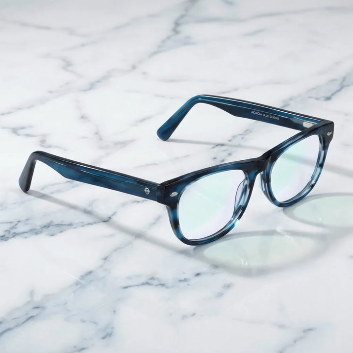 Lentes ópticos Acacia Azul sobre mármol blanco elegante armazón premium Bonoboss #editorial_armazon #color_azul