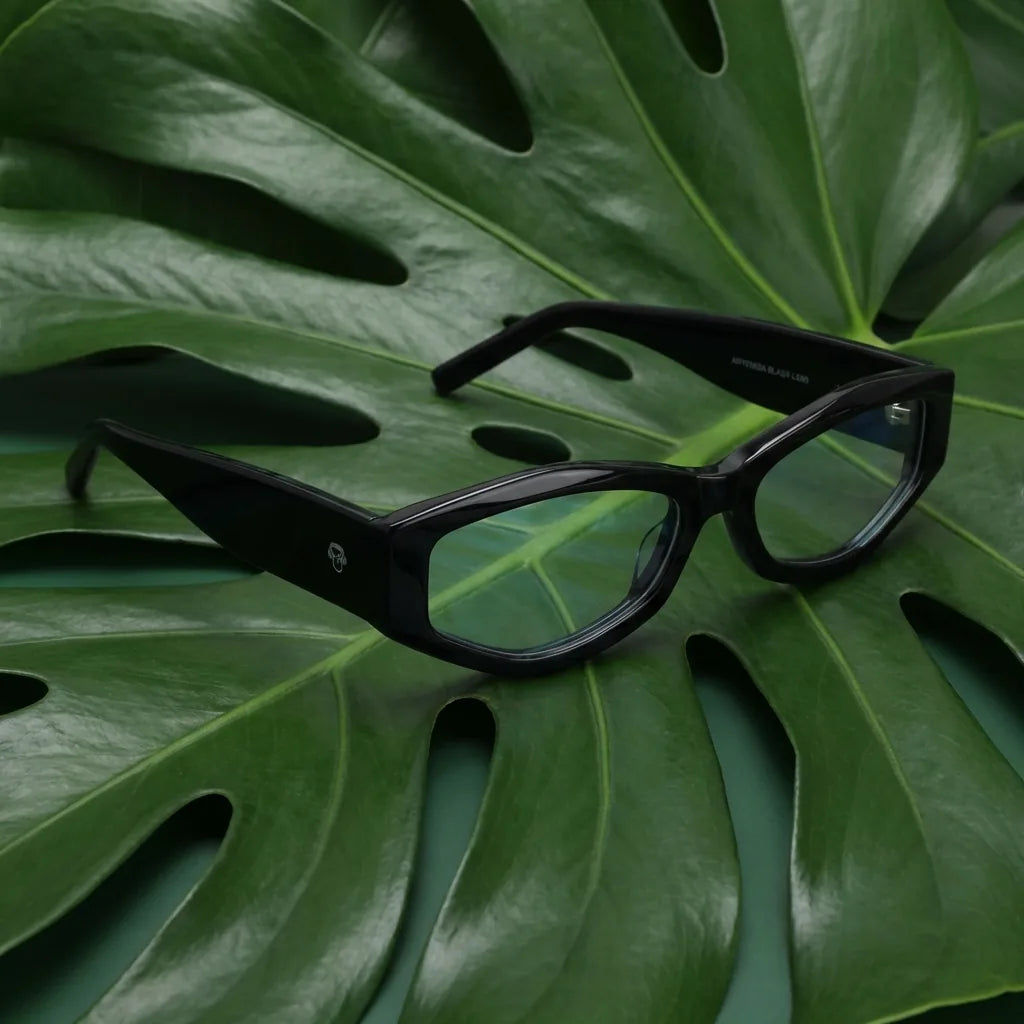 Lentes ópticos Artemisa Negro entre hojas botánicas naturales diseño sustentable Bonoboss #editorial_sustentabilidad #color_negro