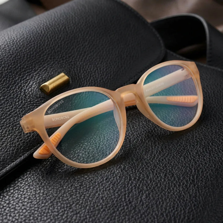 Lentes ópticos Ashley Peach sobre cuero negro con detalle brass dorado calidad premium receta Bonoboss #editorial_banner_confianza #color_peach