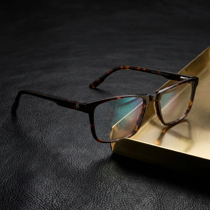 Lentes ópticos Canelo Carey sobre cuero negro con detalle brass dorado calidad premium receta Bonoboss #editorial_banner_confianza #color_carey