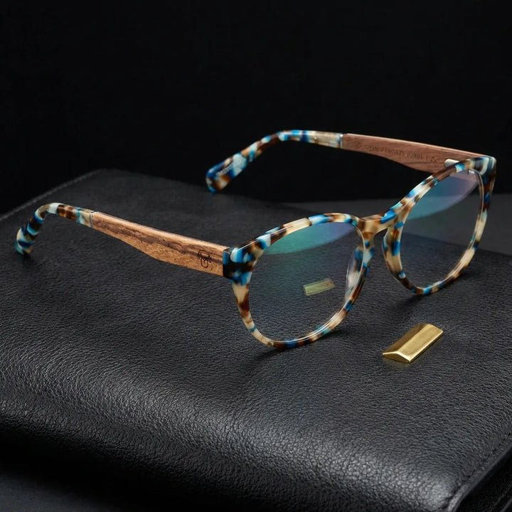 Lentes ópticos Chiloe 111 Blue sobre cuero negro con detalle brass dorado armazón premium Bonoboss #editorial_armazon #color_blue