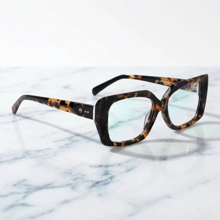 Lentes ópticos Domi Carey sobre mármol blanco elegante armazón premium Bonoboss #editorial_armazon #color_carey