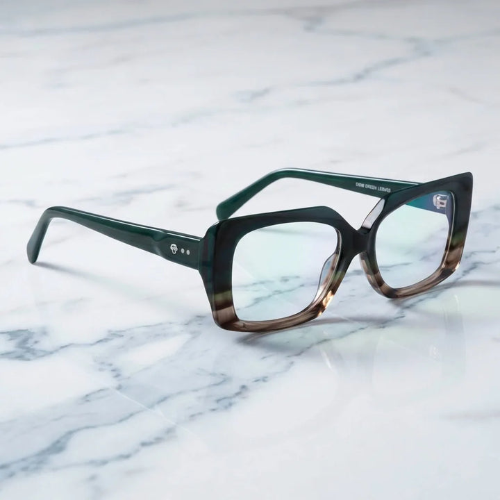 Lentes ópticos Domi Honey Green sobre mármol blanco elegante armazón premium Bonoboss #editorial_armazon #color_honey-green