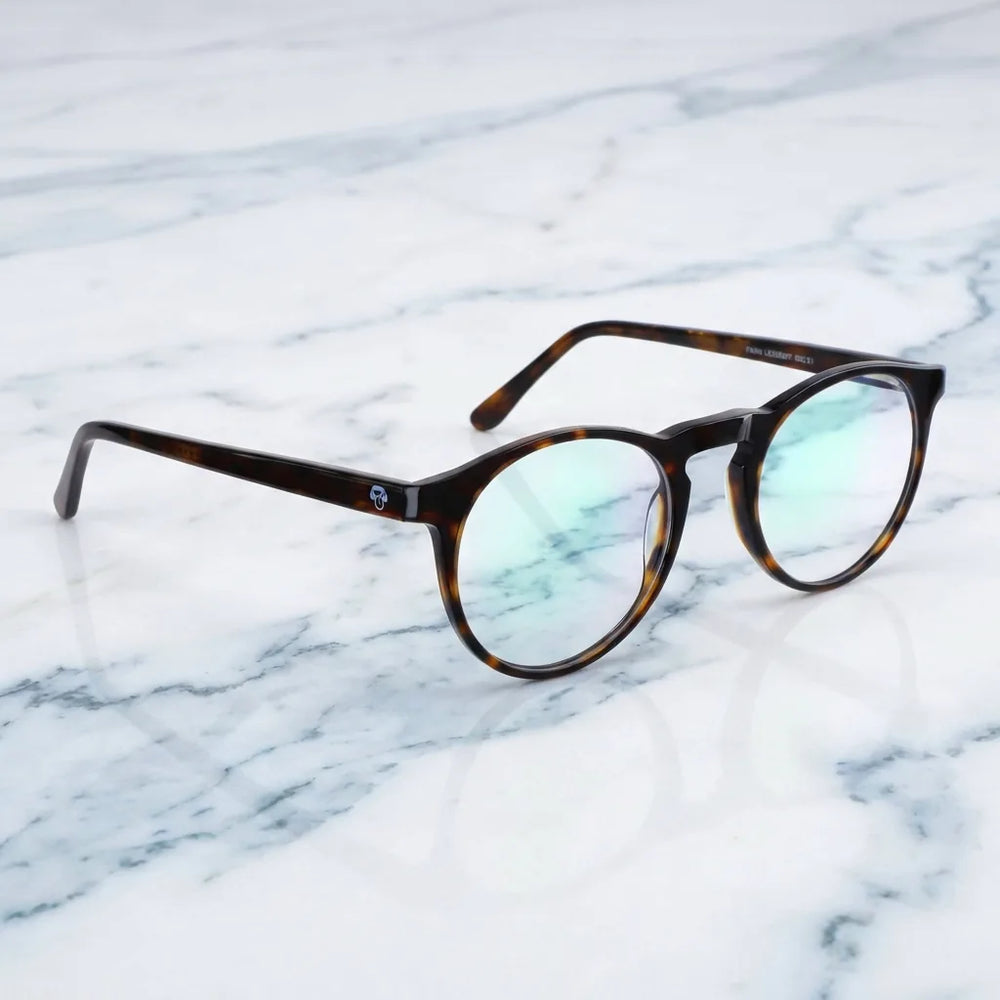Lentes ópticos Fran 1 Carey sobre mármol blanco elegante armazón premium Bonoboss #editorial_armazon #color_carey