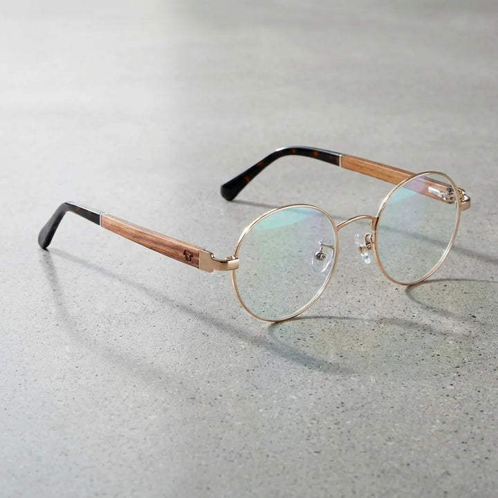 Lentes ópticos Harry Dorado sobre concreto pulido minimalista armazón premium Bonoboss #editorial_armazon #color_dorado