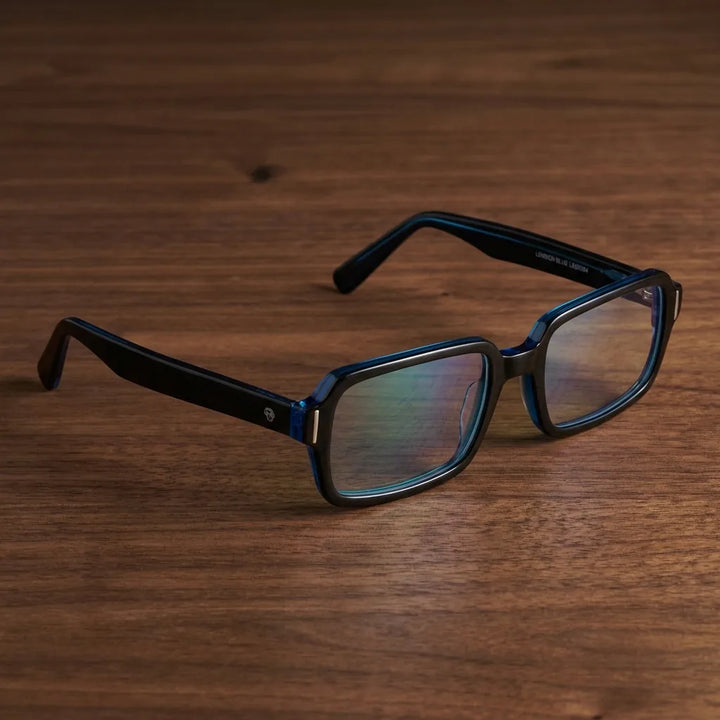 Lentes ópticos London Acetate Azul sobre escritorio de madera premium calidad premium receta Bonoboss #editorial_banner_confianza #color_azul