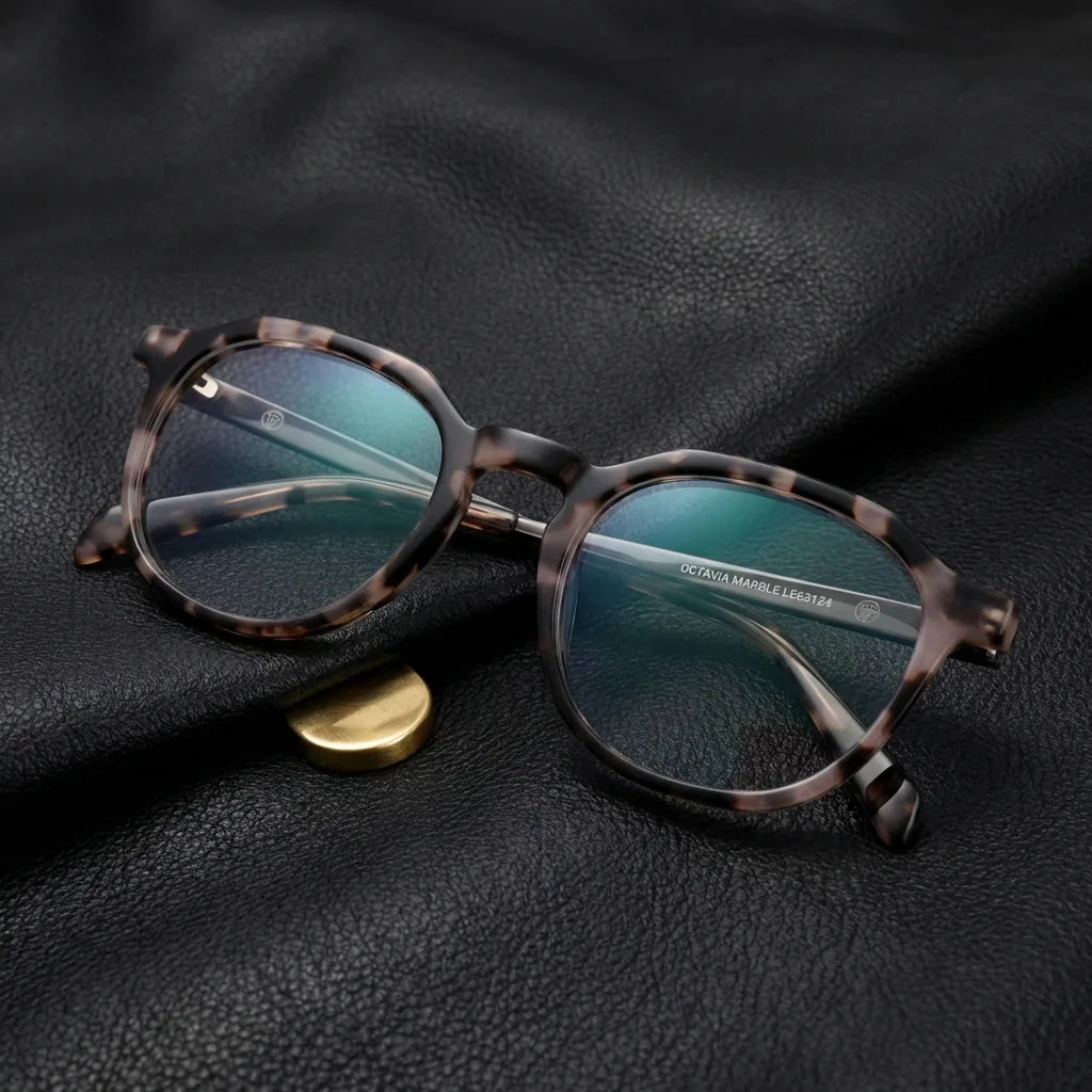 Lentes ópticos Octavia Marble sobre cuero negro con detalle brass dorado calidad premium receta Bonoboss #editorial_banner_confianza #color_marble