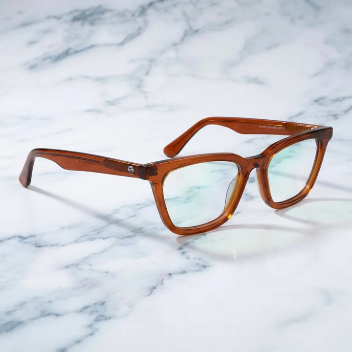 Lentes ópticos Oliver Brown sobre mármol blanco elegante armazón premium Bonoboss #editorial_armazon #color_brown