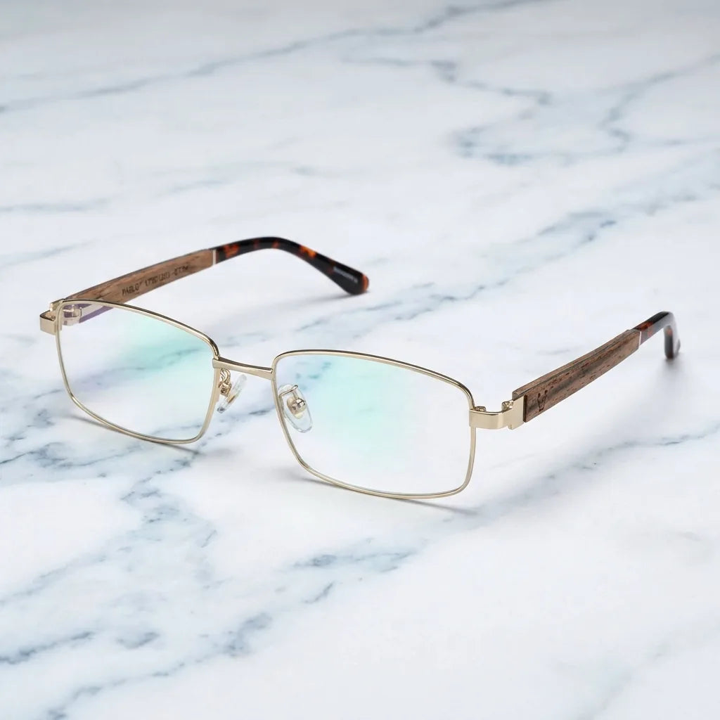 Lentes ópticos Pablo Dorado sobre mármol blanco elegante armazón premium Bonoboss #editorial_armazon #color_dorado