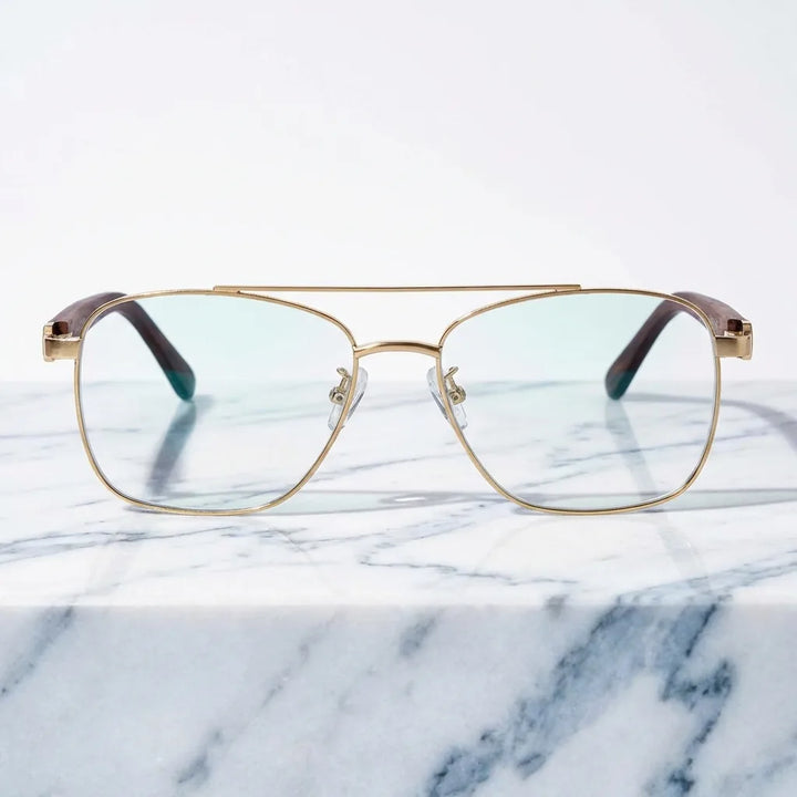 Lentes ópticos Tito Dorado sobre mármol blanco elegante armazón premium Bonoboss #editorial_armazon #color_dorado