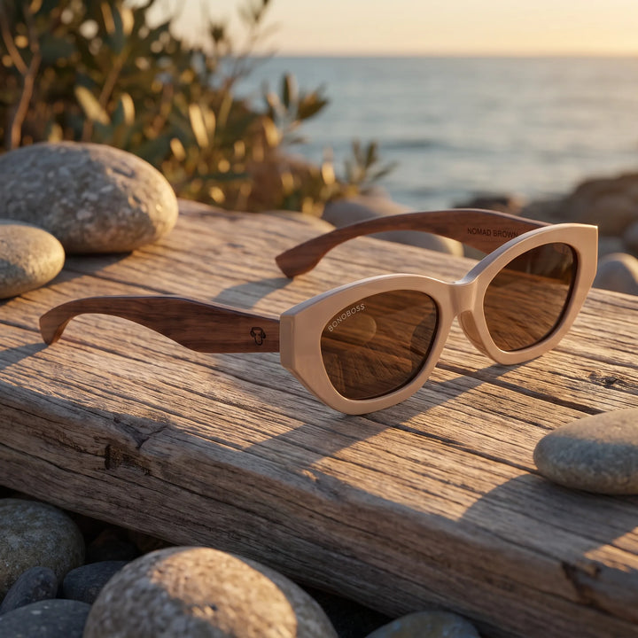 Lentes de sol Bonoboss Nomad Brown sobre madera y rocas junto al mar al atardecer #editorial_grid2 #color_brown