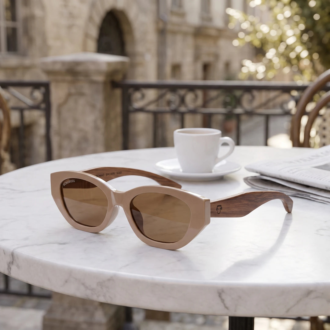 Lentes de sol Bonoboss Nomad Brown sobre mesa de mármol en terraza de café #editorial_grid1 #color_brown