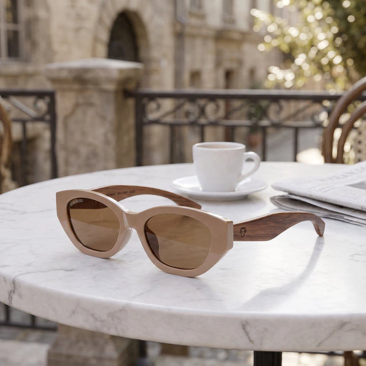 Lentes de sol Bonoboss Nomad Brown sobre mesa de mármol en terraza de café #editorial_grid1 #color_brown