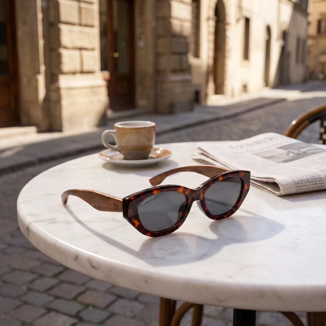 Lentes de sol Bonoboss Nomad Carey sobre mesa de mármol en terraza de café #editorial_grid1 #color_carey