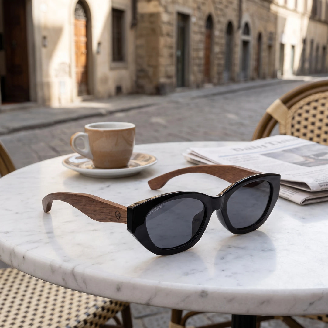 Lentes de sol Bonoboss Nomad Negro sobre mesa de mármol en terraza de café #editorial_grid1 #color_negro