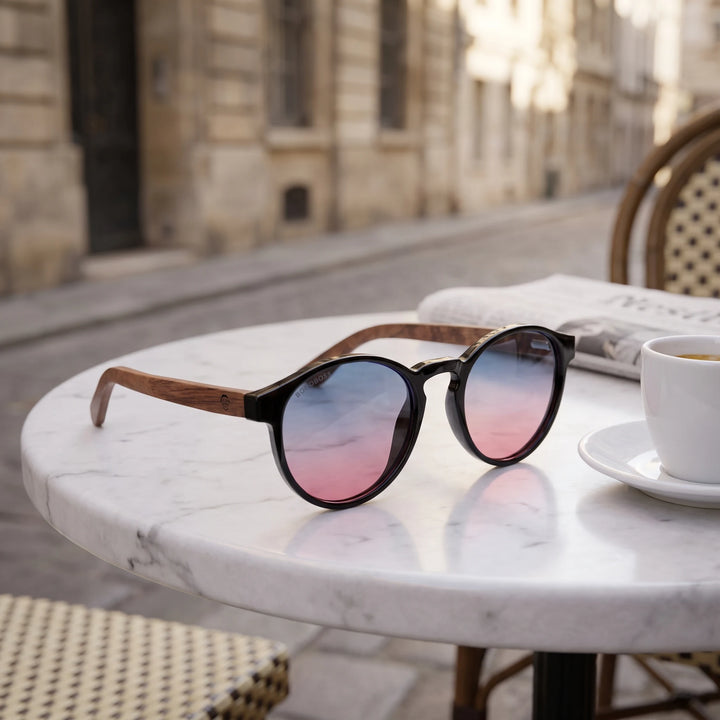 Lentes de sol Bonoboss Paine Pink sobre mesa de mármol en terraza de café #editorial_grid1 #color_pink