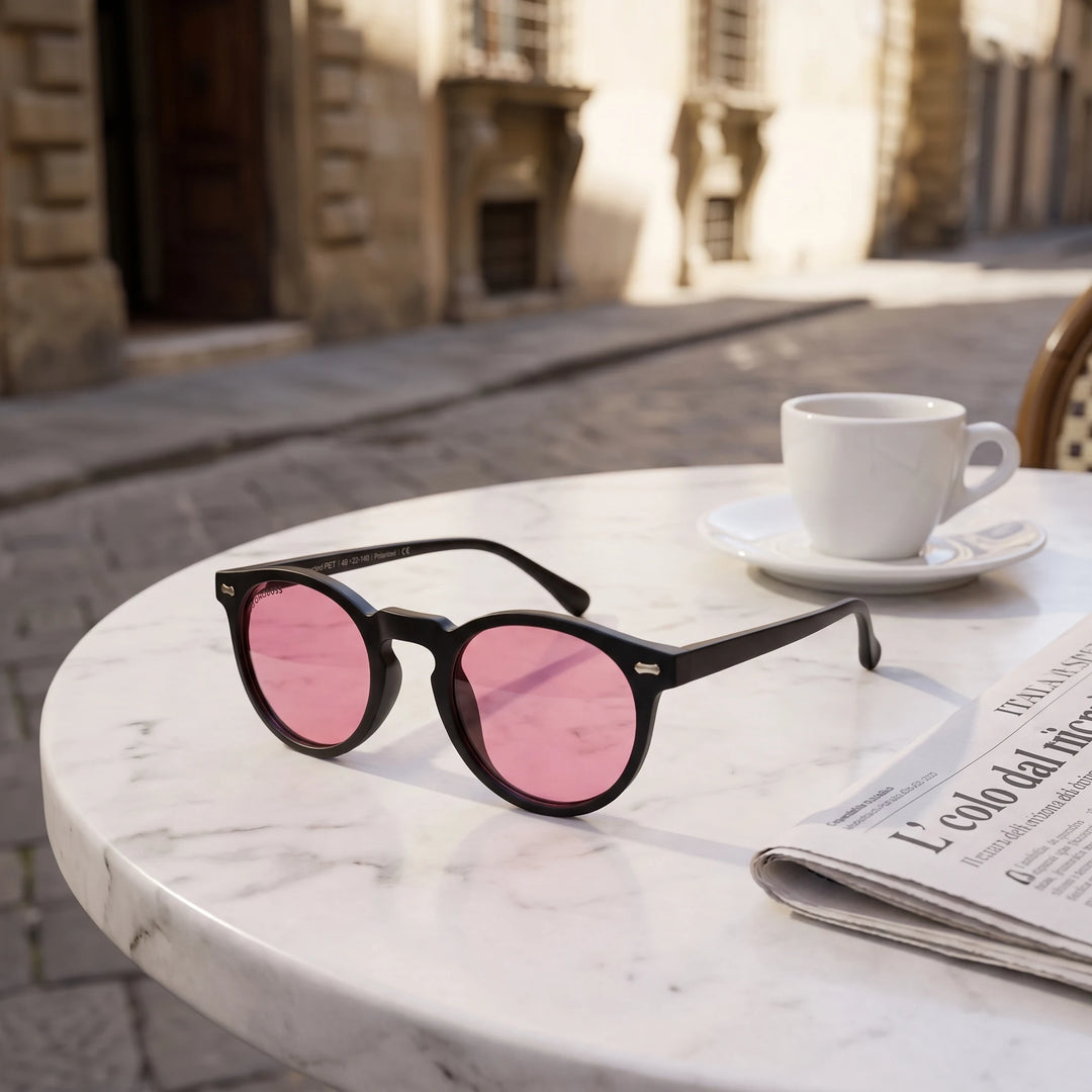 Lentes de sol Bonoboss Temuco RPET Rosado sobre mesa de mármol en terraza de café #editorial_grid1 #color_rosado
